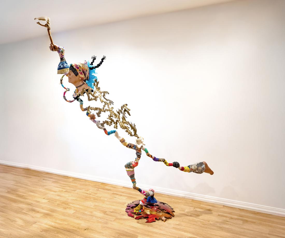 mixed media sculpture of female figure reaching above head