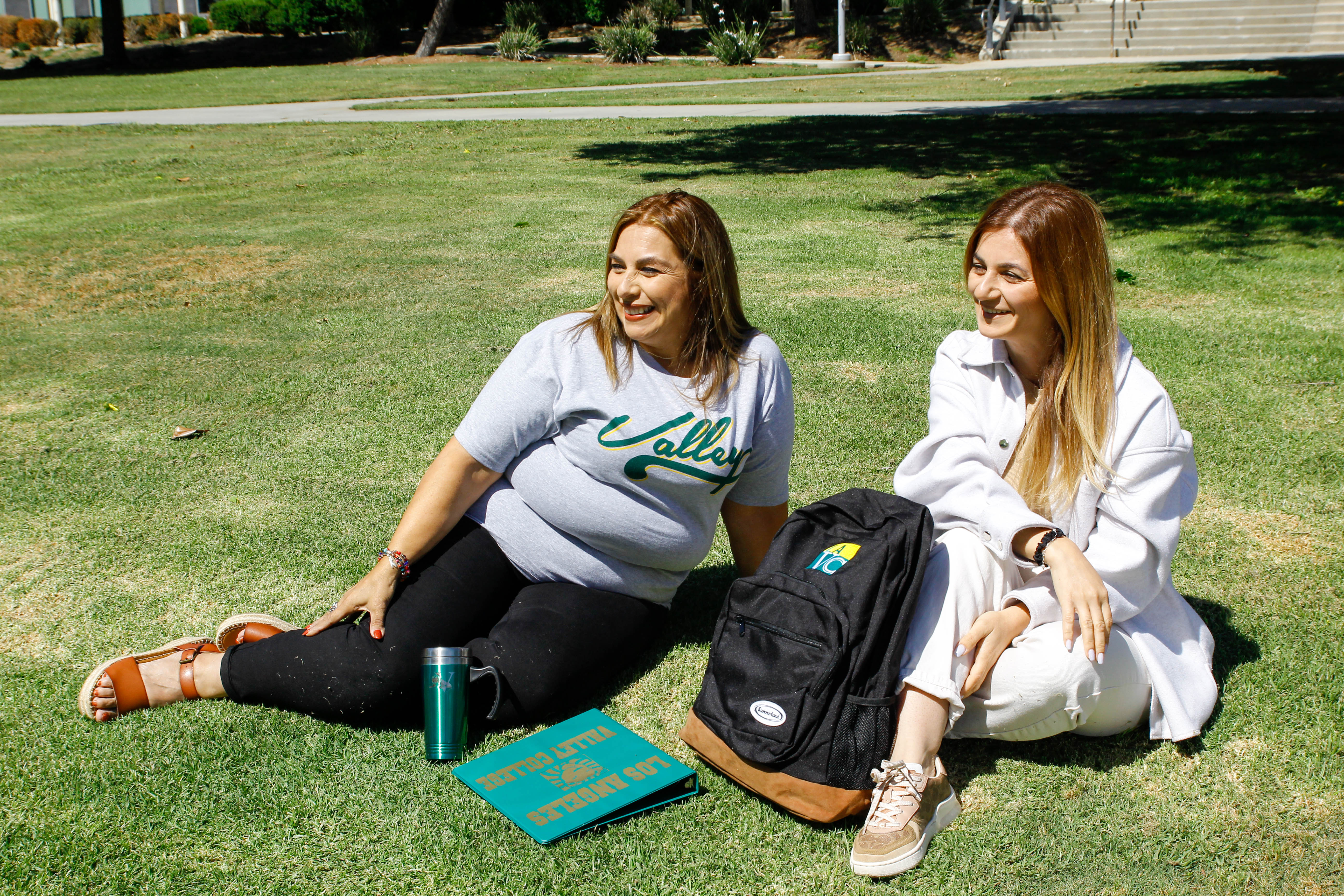 Female Students Seated at Campus Garden 