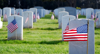 American flags in front of solider graves at cemetery