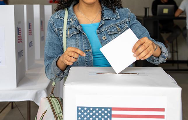 A person casting their voting ballot